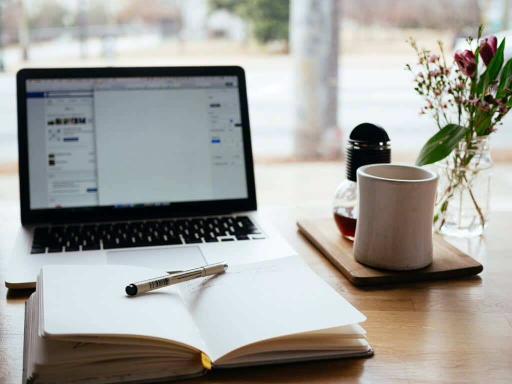 mac book with notebook and coffee mug
